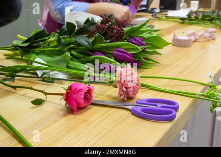 des ciseaux pour couper des fleurs se trouvent sur une table avec des fleurs dans un fleuriste Banque D'Images