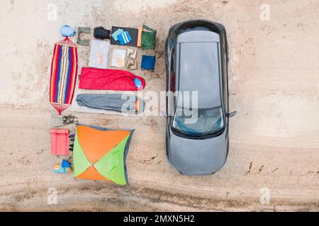 Voiture et équipement de camping sur plage de sable, vue aérienne. Voyage d'été Banque D'Images