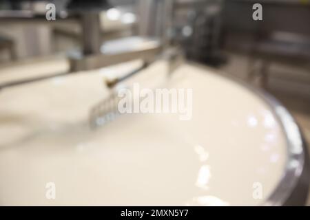 Vue floue du réservoir de préparation de caillé avec du lait à l'usine de fromage Banque D'Images