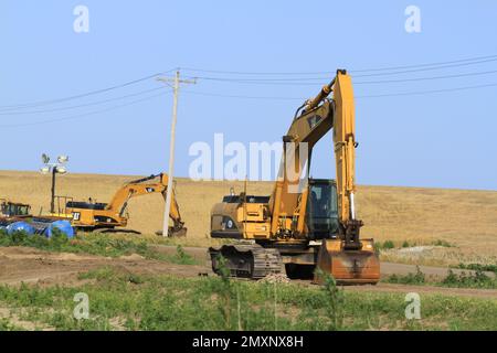 PELLE HYDRAULIQUE CAT sur un chantier prêt à travailler avec un ciel bleu à la campagne Banque D'Images