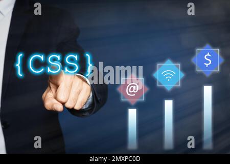 Développement Web. Homme utilisant le bouton CSS sur l'écran virtuel, gros plan Banque D'Images