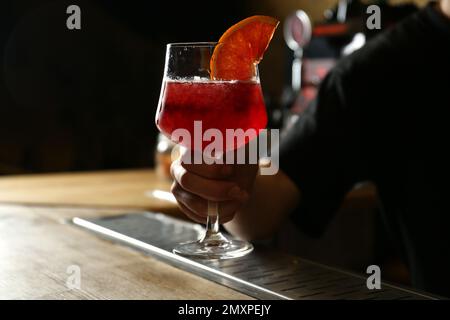 Barman tenant un verre de cocktail alcoolisé frais au bar, en gros plan Banque D'Images