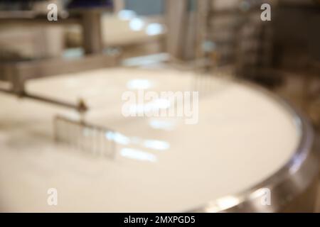 Vue floue du réservoir de préparation de caillé avec du lait à l'usine de fromage Banque D'Images