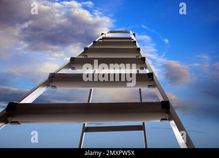 Escabeau en métal contre ciel bleu avec nuages, vue en angle bas Banque D'Images