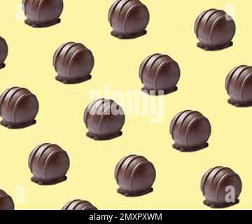 Bonbons au chocolat savoureux sur fond jaune pâle. Motif Banque D'Images