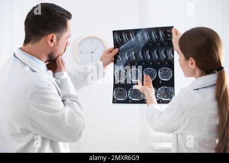 Orthopédiste professionnel et son collègue examinant l'image de rayons X au bureau Banque D'Images