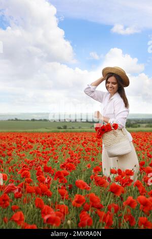 Femme avec sac à main et fleurs de pavot dans un beau champ Banque D'Images