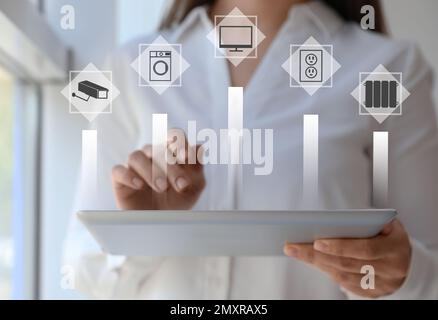 Femme utilisant une tablette pour contrôler la maison intelligente, gros plan. Systèmes automatiques Banque D'Images