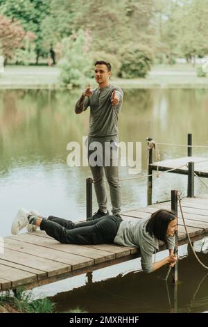 Beau couple s'amuser sur le pont dans le parc Banque D'Images