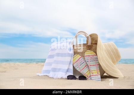 Différents objets de plage élégants sur le sable près de la mer Banque D'Images