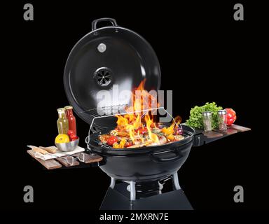 Barbecue moderne flamboyant avec des plats savoureux sur fond noir Banque D'Images