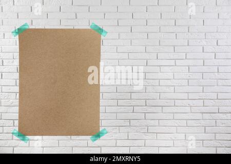 Affiche vierge fixée au mur en brique blanche. Espace de conception Banque D'Images