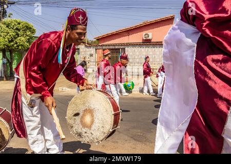 Goias, Brésil – 11 septembre 2022 : un fêtard vêtu de rouge, jouant du Bumbo dans les Congadas. Banque D'Images