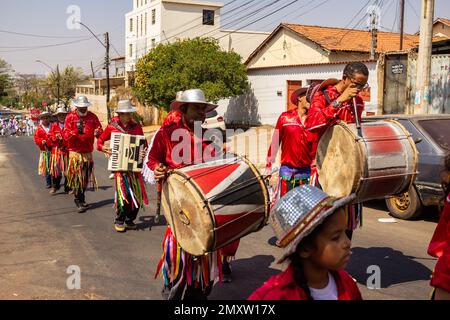 Goias, Brésil – 11 septembre 2022: Groupe de fêtards vêtus de rouge, alignés, jouant des instruments à percussion. Banque D'Images