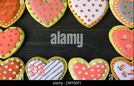 Magnifiques cadres de biscuits en forme de coeur orange et jaune sur fond noir Banque D'Images