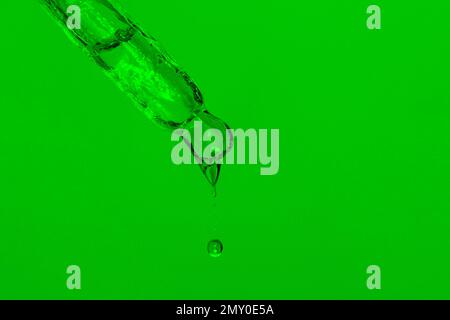 Pipette cosmétique avec liquide goutte à goutte, huile et gouttes sur fond vert, sérum, sérum, gel, vitamine, eau, huile. Cosmétiques naturels Banque D'Images