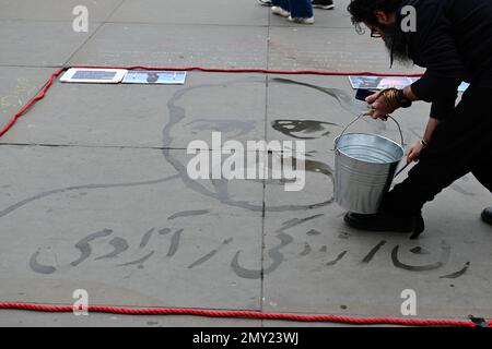 Trafalgar Square, Londres, Royaume-Uni. 4 février 2023. L'artiste Nasser Teymurpour utilise un seau d'eau de la Tamise pour faire le sacrifice de Mohammad Moradi lui-même pour 'Women.Life.Freedom' qui s'est jeté dans le Rhône à Lyon, La France proteste contre la répression généralisée du soulèvement de 2022 en Iran et dans le but d'attirer l'attention du monde entier sur le comportement violent de la République islamique à l'égard des manifestants. Crédit : voir Li/Picture Capital/Alamy Live News Banque D'Images