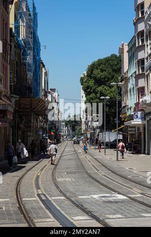 Vue à l'ouest de la rue Sete de Setembro avec les pistes de tramway de Rio de Janeiro Light Rail (VLT Carioca) fonctionnant au milieu sous le ciel bleu du matin d'été. Banque D'Images