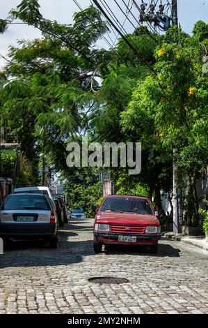 Circulation sortie Ladeira de Santa Teresa rue pavée dans le quartier de Santa Teresa, à proximité rue Dias de Barros sous ciel bleu ciel nuageux d'été. Banque D'Images