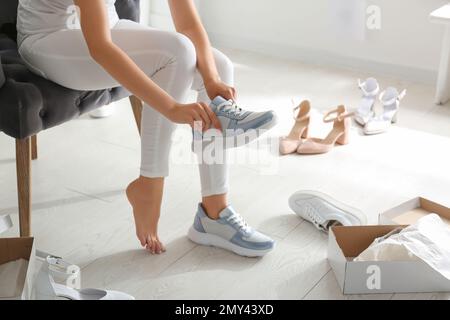 Jeune femme essayant des chaussures à l'intérieur, gros plan Banque D'Images