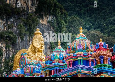 Saints colorés et Bouddha doré devant les grottes de Batu, Kuala Lumpur, Malaisie Banque D'Images