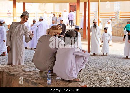 Les gens ordinaires, habillés traditionnellement, au marché du bétail de Nizwa - Oman Banque D'Images