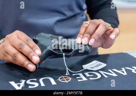 Southgate, Michigan - Une vendeuse présente un pistolet SIG Sauer à Range USA, une chaîne nationale de magasins d'armes à feu qui a ouvert son quatrième site du Michigan. Banque D'Images