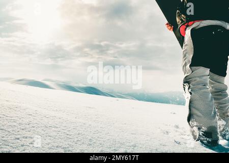 Snowboarder vêtu d'un équipement de protection complet pour le snowboard extrême freeride posé avec une marche de snowboard. Isolé sur fond de neige gris blanc Banque D'Images