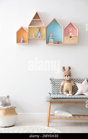 Étagères et banc en forme de maison avec jouets dans la chambre des enfants. Design intérieur Banque D'Images