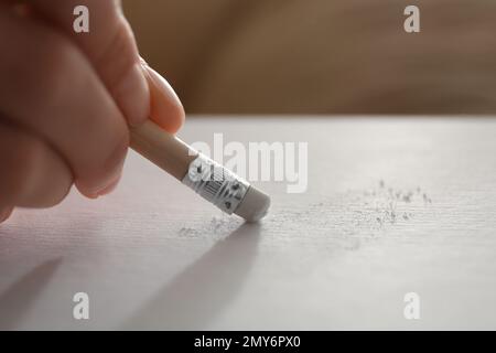 Femme corrigeant l'image sur le papier avec la gomme du crayon, gros plan Banque D'Images