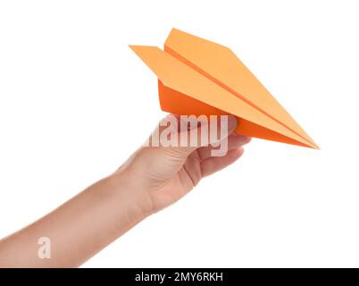 Femme tenant un avion de papier orange sur fond blanc, gros plan