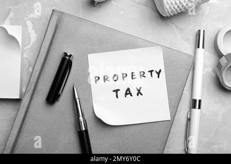 Remarque avec le texte taxe sur la propriété et papier à lettres sur la table, mise en place à plat Banque D'Images
