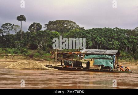 La rivière Tambopata dans le bassin amazonien du Pérou est un affluent important de la rivière Madre de Dios et de la rivière Amazone. Les dragues de l'exploitation aurifère empoisonnent la rivière avec du mercure et causent l'envasement massif qui tue les poissons et d'autres espèces aquatiques. Banque D'Images