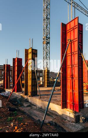 Chantier de construction avec coffrages en acier et barres de renfort pour piliers prêt pour le coulage du béton Banque D'Images