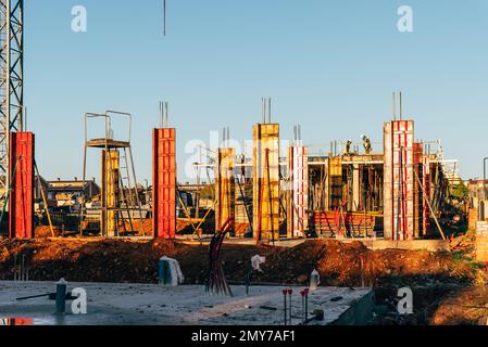 Chantier de construction avec coffrages en acier et barres de renfort pour piliers prêt pour le coulage du béton Banque D'Images