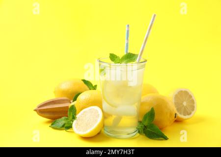 Limonade naturelle fraîchement préparée avec presse-fruits sur fond jaune. Boisson rafraîchissante en été Banque D'Images