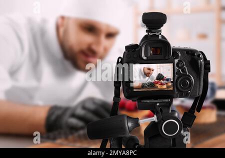 Photographie alimentaire. Prise de vue du chef décorant le dessert, mise au point sur l'appareil photo Banque D'Images