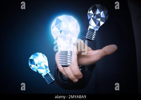 Concept d'idée. Homme d'affaires touchant l'ampoule lumineuse sur l'écran virtuel, gros plan Banque D'Images