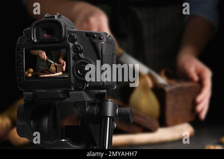 Photographie alimentaire. Prise de vue d'une femme coupant du pain de poire, mise au point sur l'appareil photo Banque D'Images