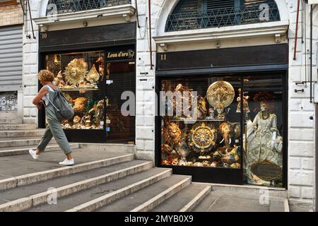 Une femme marchant devant un magasin de masques vénitiens sur le pont du Rialto vide à l'aube, Venise, Vénétie, Italie Banque D'Images