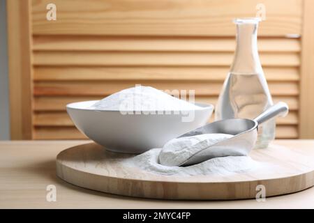 Bicarbonate de soude dans une pelle et bol sur une table en bois Banque D'Images