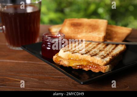 Délicieux sandwich à la confiture d'abricot et au beurre d'arachide pour le petit déjeuner sur table Banque D'Images