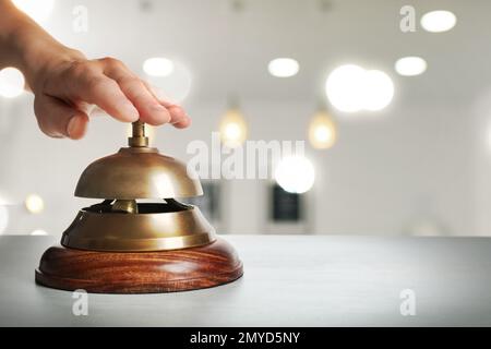 Homme sonnant le service de l'hôtel sur fond flou, gros plan. Espace pour le texte Banque D'Images