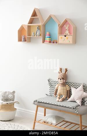 Étagères et banc en forme de maison avec jouets dans la chambre des enfants. Design intérieur Banque D'Images