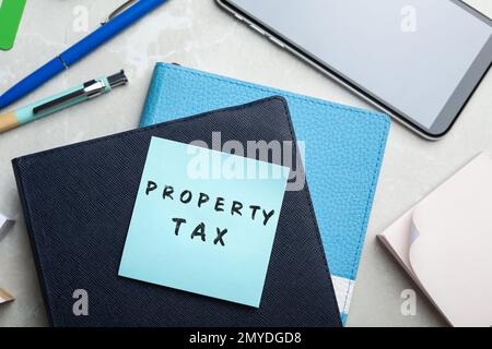 Remarque avec le texte taxe sur la propriété et papier à lettres sur la table, mise en place à plat Banque D'Images