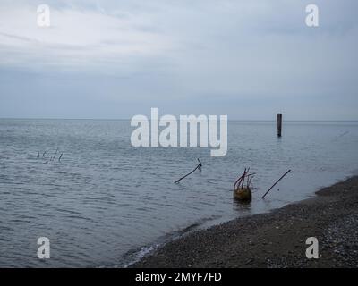 météo loudy en mer. Une atmosphère de tristesse et de destruction. Les restes d'une structure en béton sortent de l'eau. Après la tempête. Abandonné Banque D'Images