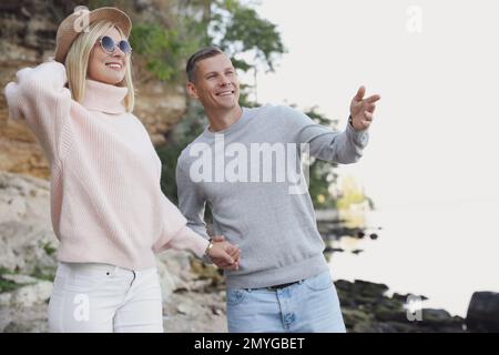 Couple heureux en pulls élégants sur la plage Banque D'Images