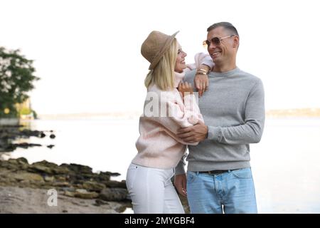 Couple heureux en pulls élégants sur la plage Banque D'Images