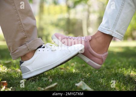 Homme et femme se cognant les jambes pour dire bonjour à l'extérieur, gros plan. Garder la distance sociale pendant la pandémie du coronavirus Banque D'Images