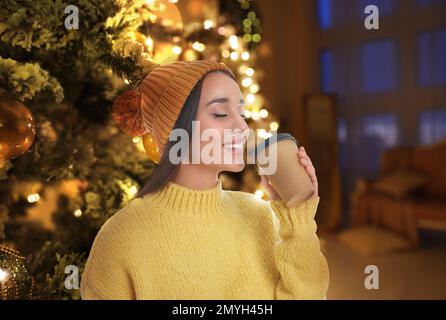 Belle femme heureuse avec menué près de l'arbre de Noël à l'intérieur Banque D'Images